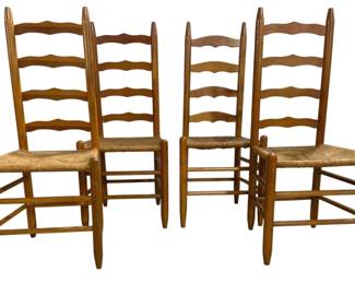 7660 - 4 Ladder Back Chairs w/ Rush Seats (Description): Set of four ladder back chairs featuring  woven rush seats. The chairs are constructed  of warm-toned wood with four horizontal slats  forming the ladder back design and pointed  finials at the top. Each chair includes turned stretchers for stability.  Measurements: 23" x 14" x 19".