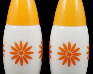 1029 - Gemco Orange Flower Power S&P Set 3.5" (Description): Gemco Orange Flower Power salt and pepper  shaker set. This charming mid-century modern  pair features white milk glass bodies  decorated with bold orange daisy motifs,  topped with bright yellow plastic lids. Each shaker measures 3.5 inches tall.