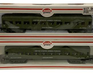 1597 - 2pc Model Power HO Army Train Cars Set (Description): Two-piece set of Model Power HO scale army  train cars. The passenger/troop carrier cars  are finished in olive drab military green and  marked "United States Armed Forces" with  "Rapid Deployment" and "Spl. Force" designations. Both cars appear troop carriers  and come in their original Model Power  packaging.