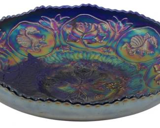 714 - Vtg Fenton Cobalt Blue Dragon & Lotus Bowl (Description): Vintage Fenton cobalt blue carnival glass  bowl in the Dragon and Lotus pattern. This  striking piece features an iridescent finish  with rich purple, gold, green, and blue tones  characteristic of fine carnival glass. The bowl displays decorative medallions featuring  dragons and floral motifs around the rim,  with an ornate lotus-inspired center design  and scalloped edge. Measures 2 inches tall by  8 inches in diameter.