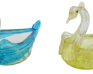 748 - 2 Vintage Murano Glass Swans 3" (Description): Two vintage Murano glass swan figurines, each  measuring 3 inches. The pair features one  swan in vibrant blue and turquoise tones with  a gracefully curved neck, and one in soft  yellow with clear glass accents. Both are crafted in the traditional Venetian style  with delicate detailing on the wings and  bodies, suitable for use as decorative pieces  or small trinket dishes.