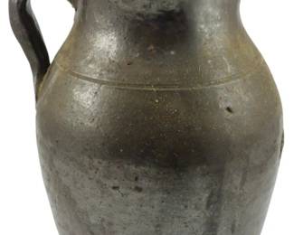 607 - 19th C. Southern Alkaline Stoneware Pitcher (Description): A 19th century Southern alkaline glazed  stoneware pitcher featuring a single handle  and characteristic glaze finish typical of  the region's pottery tradition. Measures 10  inches in height.