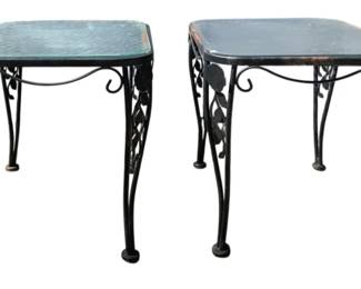 7695 - Pr Metal / Glass Top End Tables 20x25x19 (Description): Pair of wrought iron end tables with glass  tops. The tables feature decorative  scrollwork legs adorned with leaf motifs and  curved feet, finished in black. Each table  measures 20 inches by 25 inches by 19 inches tall.