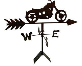 7705 - Motorcycle Weathervane 29"x26"x14" (Description): Metal motorcycle weathervane featuring a  silhouette-style chopper design mounted on an  arrow directional. The piece includes  cardinal direction indicators (N, S, E, W)  and a mounting bracket base. The weathervane displays a rustic brown patina finish.  Measures 29 inches by 26 inches by 14 inches.