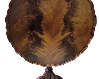 7645 - Chippendale Style Mahogany Tilt-Top Table (Description): Chippendale style mahogany accent table  featuring a tilt-top mechanism with birdcage  support. The table stands on a carved  pedestal base with acanthus leaf detailing  and terminates in three cabriole legs with ball and claw feet. The circular top has a  pie crust edge. Measures 24" x 30".
