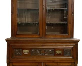 7783 - English Victorian Carved 2 Piece Bookcase (Description): With rich carved detail throughout. The upper  section features two glass-paneled doors  with fluted pilasters and carved rosette  corner blocks beneath a dentil molded  cornice. The lower section includes a long drawer with foliate carving and brass  shell-form pulls, above two paneled cabinet  doors with matching carved accents. Measures  93 inches high by 43 inches wide by 21 inches  deep.