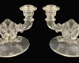 2004 - Pair Clear Glass Double Arm Candelabras (Description): A pair of elegant clear pressed glass double  arm candelabras featuring a decorative shell  or fan-shaped center motif with scrolled arms  extending to hold two candles each. The  candleholders rest on smooth circular bases and display an Art Deco-influenced design.  Measurements: 5.5" x 7.5".