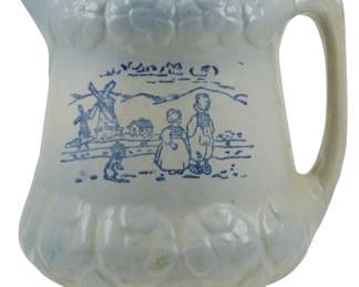 744 - Vtg McCoy Stoneware Blue & White Pitcher (Description): Vintage McCoy stoneware pitcher in blue and  white. The pitcher features a charming Dutch  scene with a windmill, cottage, and figures  in traditional dress with a chicken. The body  displays raised decorative bands at the top and bottom rim. Measures 7 inches.