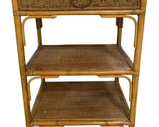 7654 - Wicker/Bamboo 3 Tier Table 32"x22"x16" (Description): Wicker and bamboo three-tier table featuring  a woven rattan drawer at the top with a brass  ring pull handle. The piece has a natural  honey-toned bamboo frame with wrapped joints  and two lower woven rattan shelves for additional storage. The coastal-style design  makes this table versatile as a nightstand,  side table, or accent piece. Measures 32  inches high by 22 inches wide by 16 inches  deep.