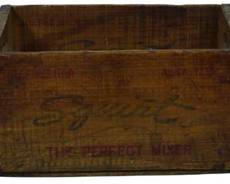 953 - Vintage Squirt Soda Wooden Crate 8"x16"x10" (Description): Vintage Squirt soda wooden crate featuring  the brand's distinctive script logo and "The  Perfect Mixer" slogan printed in red  lettering. The crate also displays  "Refresher" and "Alkalizer" text along the upper edge. Constructed of natural wood metal  reinforced corners and edges, showing  authentic aged patina and wear consistent  with its age and use. Measures 8 inches tall  by 16 inches wide by 10 inches deep.