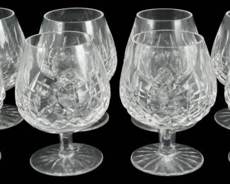 914 - 8 Waterford Crystal Lismore Brandy Snifters (Description): Set of eight Waterford Crystal brandy snifter  glasses in the classic Lismore pattern. Each  glass features the distinctive Lismore cut  design with its signature diamond and wedge  cuts that create brilliant light refraction. The snifters have a traditional balloon shape  with short stems and circular bases, ideal  for serving brandy or cognac. Measures 5.5  inches tall.