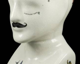 1023 - Phrenology Head Figure w/ Tattoo Decor 9.5" (Description): A ceramic phrenology head figure featuring a  distinctive crackle glaze finish and  decorated with colorful tattoo-style imagery.  The bust displays traditional tattoo motifs  including swallows, roses, anchors, and stars, along with a painted handlebar  mustache. Various phrenology-related text  labels appear across the head. A banner  reading "Phrenology" adorns the base.  Measures 9.5 inches tall.