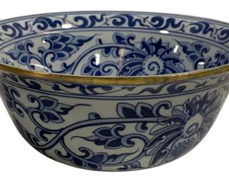 1503 - Blue & White Ceramic Bowl w/ Gold Rim 10.5" (Description): A decorative blue and white ceramic bowl  featuring traditional floral and scrolling  foliate designs. The bowl is adorned with a  gold-toned metal rim accent. The interior  displays a central medallion with stylized floral motifs surrounded by flowing botanical  patterns, while the exterior continues the  blue and white theme with complementary  scrollwork and leaf designs. Measures 10.5  inches round.