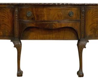 7778 - English Carved Chippendale Mahogany Buffet (Description): Chippendale style mahogany buffet featuring a  serpentine front with a central drawer  flanked by two cabinet doors. The piece  displays beautiful flame mahogany veneers and  carved rosette details on the front corners. The top features a carved gadrooned edge.  The buffet rests on six cabriole legs with  acanthus leaf carvings terminating in ball  and claw feet. Fitted with brass ring pull  hardware. Measures 35 inches high by 72
