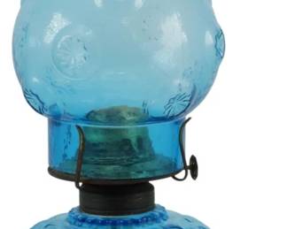 877 - Vintage L.E. Smith Blue Glass Oil Lamp 12" (Description): Vintage L.E. Smith blue glass oil lamp  featuring the iconic Moon and Stars pattern.  The lamp includes a pressed glass base with  an applied handle, brass-tone burner collar,  and a matching ruffled chimney shade with embossed floral and star motifs. Measures 12  inches tall.
