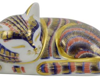 792 - Royal Crown Derby Sleeping Kitten Paperweight (Description): Royal Crown Derby sleeping kitten paperweight  decorated in the classic Imari pattern  featuring cobalt blue, coral red, and gold  gilt detailing. This charming porcelain  figurine depicts a curled sleeping cat with intricate hand-painted striped patterns. No  stopper. Measures 2 inches.