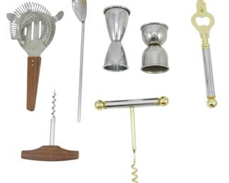 1253 - Assorted Barware Collection (Description): Assorted barware collection featuring a  variety of cocktail accessories. The lot  includes a cocktail strainer with wooden  handle, a long-handled bar spoon, two  stainless steel double jiggers, a decorative bottle opener with gold-tone accents, and two  corkscrews — one with a wooden T-handle  and another with a gold-tone and chrome  finish. A versatile set of bar tools suitable  for entertaining.
