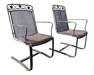 7698 - Pr Vtg Metal Mesh Patio Spring Chairs (Description): Pair of vintage metal outdoor patio chairs  featuring spring cantilever bases for  comfortable rocking motion. The chairs have  expanded metal mesh seats and backs with  decorative scrollwork and leaf motif accents along the top rail. Black painted finish  showing weathered patina consistent with age  and outdoor use. Each chair measures 37  inches high by 24 inches wide by 24 inches  deep.