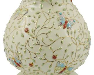 772 - Lenox 2005 Summer Enchantment Vase 8" (Description): Lenox 2005 Summer Enchantment vase featuring  an elegant cream-colored porcelain body  decorated with raised enamel butterflies,  ladybugs, and trailing vine motifs. The piece  is accented with gold trim along the rim and base, with delicate jeweled embellishments  on the butterflies. Measures 8 inches tall.
