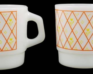 1097 - 2 Vtg Thermocrisa Orange Lattice Yellow Mugs (Description): Pair of vintage Thermocrisa milk glass  stackable mugs featuring an orange lattice  pattern with yellow tulip flowers and dots on  a white background. These charming  mid-century style mugs have the characteristic D-shaped handles and stackable  base design. Measures 3.5" tall.