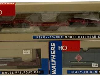 1622 - 3pc Walthers HO Scale Model Railroad Cars (Description): A lot of three Walthers HO scale ready-to-run  model railroad cars in original packaging.  The collection includes a red flatcar, a  Norfolk Southern hopper car, and a Reading  Lines caboose in green. All cars are boxed in their original Walthers packaging.