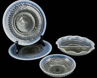 931 - Anchor Hocking Moonstone Glass Items (Description): Assorted Anchor Hocking Moonstone pattern  glassware pieces. The collection features the  signature opalescent hobnail design with  delicate blue-white edges characteristic of  the Moonstone pattern. Includes plates and bowls of varying sizes, each displaying the  distinctive crimped or ruffled rims and  starburst center motifs typical of this  popular mid-century American pressed glass  pattern.