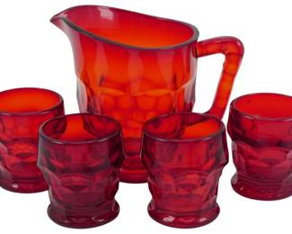 760 - Vtg Ruby Red Glass Pitcher Set w/ 4 Tumblers (Description): Vintage ruby red glass pitcher set featuring  a large pitcher with applied handle and four  matching tumblers. The set displays a  distinctive thumbprint or coin dot pattern  throughout. The deep ruby red color transitions from darker red at the base to a  brighter orange-red near the rim. Measures  4.5 inches.