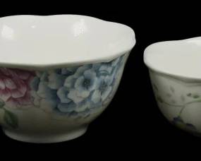 778 - 4 Lenox Butterfly Meadow Bowls (Description): Set of four Lenox Butterfly Meadow bowls  featuring delicate floral designs. The  collection includes two larger bowls  decorated with blue and pink peony blossoms  and two smaller bowls with trailing vine and leaf motifs. Each bowl features a scalloped  rim and white porcelain body characteristic  of the Butterfly Meadow collection.
