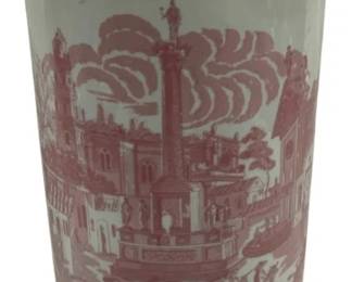 1502 - Pink & White Transferware Umbrella Stand (Description): Pink and white ceramic umbrella stand  featuring transferware decoration with scenic  imagery depicting a European town square  with a central monument, figures on  horseback, and architectural vignettes in car touches around the rim. The cylindrical form  displays classic toile-style pastoral  scenes. Measures 17.5 inches tall by 7.5  inches in diameter.