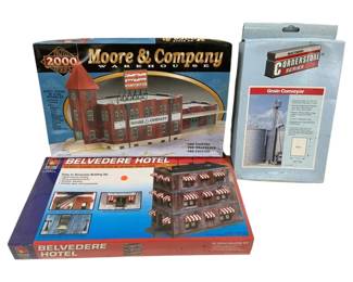 1676 - 3pc Lot HO Scale Model Building Kits (Description): A lot of three HO scale model building kits.  Includes a Proto 2000 Series Moore & Company  Warehouse kit featuring a pre-painted,  pre-weathered, and pre-printed industrial  building. Also included is a Walthers Cornerstone Series Grain Conveyor kit and an  IHC Belvedere Hotel kit, an easy to assemble  building designed for use with all HO scale  train layouts. All kits remain in their  original boxes.
