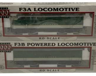 1592 - Proto 1000 F3A/F3B 2pc HO Locomotive Set (Description): Proto 1000 Series F3A/F3B two-piece  locomotive set in HO scale. This set includes  an F3A locomotive and an F3B powered  locomotive, both decorated in Southern  Railway green and white livery. The models feature Proto 2000 magnetic knuckle couplers,  constant and directional lighting, and dual  machined brass flywheels. Both locomotives  come in their original packaging.