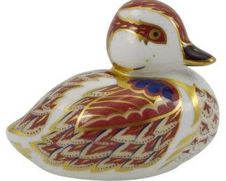 794 - Royal Crown Derby Duckling Paperweight (Description): Royal Crown Derby swimming duckling  paperweight featuring the iconic Imari color  palette of rich reds, cobalt blue, and  22-carat gold accents. The decorative bird  displays intricate hand-painted feather detailing across its body with gilded  highlights throughout. This piece is fitted  with a gold stopper, indicating a limited or  special edition. Measures 2.5 inches.