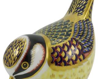 793 - Royal Crown Derby Blue Tit Paperweight Gold (Description): Royal Crown Derby Blue Tit paperweight  featuring a gold stopper. This charming bone  china bird figurine showcases the brand's  signature Imari-style decoration with  intricate hand-painted details in cobalt blue, gold, yellow, red, and black. The  stylized feather patterns and gilded accents  are characteristic of Royal Crown Derby's  collectible paperweight series. Measures 3  inches.