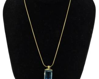 825 - 14K Gold Band & 13K Gold Pendant Necklace (Description): A 14K gold necklace featuring a delicate  snake chain and a striking 13K gold pendant.  The pendant showcases a large emerald-cut  blue topaz stone set in a simple gold bezel  mount. Total weight is 0.55 oz.