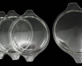 1232 - 4 Assorted Pyrex Clear Glass Lids (Description): A collection of four assorted Pyrex clear  glass lids with tab handles. The lids feature  the characteristic Pyrex branding and appear  to be replacement lids suitable for various  Pyrex casserole dishes and bakeware.