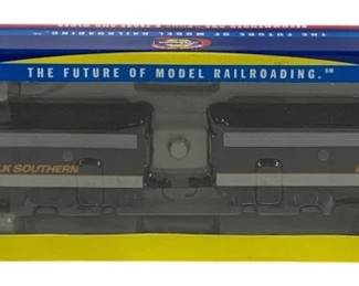1604 - Athearn Norfolk Southern HO Scale Locomotive (Description): Athearn Norfolk Southern locomotive and car  set. This HO scale model railroad set  features Norfolk Southern livery in the  characteristic black and gray color scheme  with the NS logo. The set includes locomotive #4271 and car #4275, presented in the  original Athearn blue and yellow display  packaging marked with "The Future of Model  Railroading" slogan.