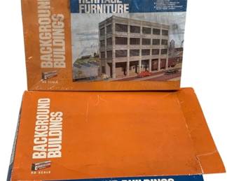 1680 - 2 pc. Lot Cornerstone HO Scale Model Kits (Description): A lot of two Cornerstone Series HO scale  model kits from the Background Buildings  collection. The lot includes the Heritage  Furniture building kit, which depicts a  multi-story industrial or commercial building. Both kits are in their original  orange and blue packaging. These kits are  designed to add depth and realism to HO scale  model railroad layouts.