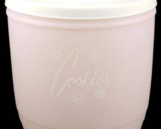 1106 - Stanley Pink Blush Plastic Cookie Canister (Description): Vintage Stanley pink blush plastic cookie  canister featuring the word "Cookies" in  white script lettering with decorative  starburst accents. The canister has a  rounded, tapered design with horizontal ribbing near the base and comes with a white  platic lid with a finger tab for easy  removal. Measures 7.5 inches by 7.5 inches.