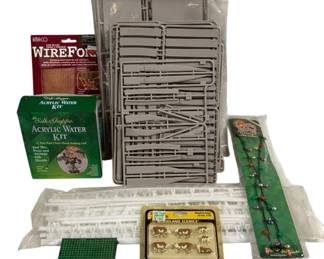 1692 - Assorted Model Making & Craft Supplies Lot (Description): Assorted lot of model making and craft  supplies including an Amaco WireForm copper  mesh, a Silk Shoppe Acrylic Water Kit for  creating realistic water effects with silk  floral, gray plastic model spruces with fencing and structural components, white  plastic picket fence sections, a Woodland  Scenics HO scale Hereford Cows set, green  plastic craft mesh grid, and an Old Fashioned  Christmas light bulb necklace. Items appear