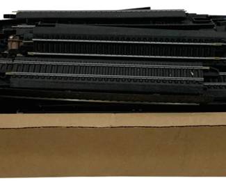 1643 - Box Lot HO Scale Train Tracks (Description): A box lot of HO scale model train tracks. The  collection includes multiple sections of  black plastic track in varying lengths,  suitable for model railroad layouts. The  tracks are stored in a cardboard box.