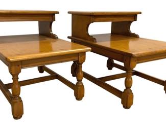 7659 - Pair Lane Mid-Century Two-Tier Inlaid Tables (Description): Pair of two-tier end tables crafted in warm  wood with a honey-toned finish. Each table  features a rectangular lower surface with a  smaller raised upper shelf supported by  graceful scrolled brackets. The tables rest on sturdy turned baluster legs connected by  stretcher base. The wood shows natural  character and patina consistent with vintage  construction. Measurements: 42"x14"x18" and  23"x22"x10".