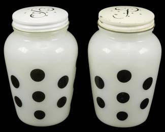 1022 - Pr Fire King Black Polka Dot Shakers 4.5" (Description): Pair of Fire King milk glass salt and pepper  shakers featuring a black polka dot pattern.  The white metal lids are decorated with an  ornate scrollwork design and have the  appropriate S and P perforations. These charming mid-century shakers measure 4.5  inches tall.