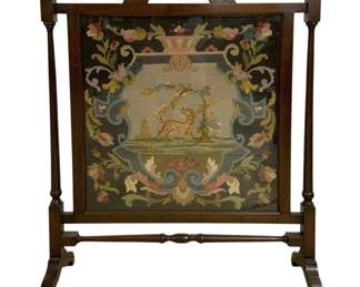 7740 - Vintage Needlepoint Fireplace Screen 35"x28" (Description): Vintage needlepoint fireplace screen set in a  mahogany-finished wooden frame with ball  finials and turned posts. The handworked  needlepoint panel features a central  cartouche depicting a heraldic lion beneath a tree, surrounded by elaborate scrolling  acanthus leaves, florals, and an urn motif  against a dark ground. The screen rests on  curved sled-style feet connected by a turned  stretcher bar. Measures 35 inches by 28