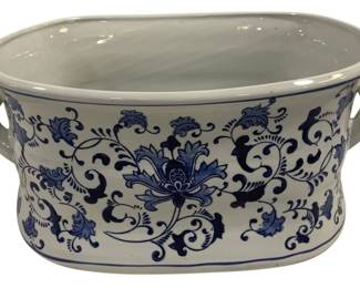 1542 - Blue & White Ceramic Footbath Planter (Description): Blue and white ceramic footbath-style planter  or tub featuring traditional  Chinese-inspired floral and scrolling vine  motifs. The oval vessel has two handles on  opposite sides and displays a classic lotus flower design with surrounding foliate  decoration. Measures 19 inches by 13 inches  by 8.5 inches.