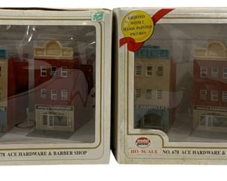 1046 - 2pc Lot Model Power Lighted Storefronts (Description): Two piece lot of Model Power lighted  storefronts. These HO scale buildings feature  the No. 678 Ace Hardware & Barber Shop  design, each lighted with two hand painted  figures included.