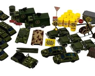 1572 - Lot Military Die-Cast Vehicles & Accessories (Description): A collection of military die-cast vehicles  and accessories. The lot includes multiple  camouflage-patterned jeeps and cars, olive  drab military trucks and utility vehicles,  tanks, helicopters, and an assortment of play accessories including yellow fuel barrels,  road signs, crates, and other military base  equipment. The vehicles feature various  military markings including star insignias  and "Army Patrol" designations.