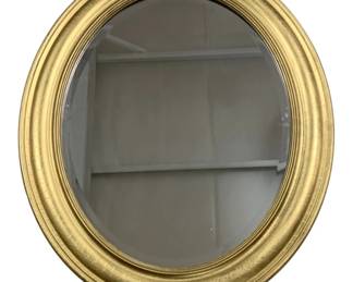 7721 - Gold Gilt Oval Wall Mirror 38"x24" (Description): Oval wall mirror featuring a gold gilt frame  with a classic stepped molding design. The  mirror has a beveled edge and the frame  exhibits an attractive crackled patina finish  consistent with vintage or antique-style pieces. Measures 38 inches by 24 inches.