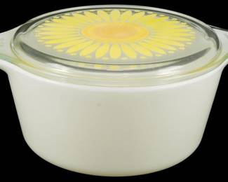1191 - Pyrex Sunflower Large Casserole w/ Lid (Description): Pyrex Sunflower pattern large casserole dish  with matching lid. The white milk glass bowl  features the iconic Sunflower design on the  clear glass lid, displaying a bold yellow and  orange daisy motif with a decorative border. This vintage piece includes the original  fitted lid with tab handles. Measures 4  inches tall by 9 inches wide by 7 inches  deep.