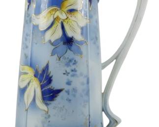 771 - Vintage Floral Porcelain Pitcher Tankard (Description): Featuring a striking blue ombre body  decorated with hand-painted orchid blossoms  in cream, yellow, and blue tones with gilt  accents. The rim is adorned with an elaborate  raised gold stippled design with small white floral details. The elegant Art Nouveau  style handle has a distinctive looped design  in pale blue-green porcelain. Measures 13  inches tall.