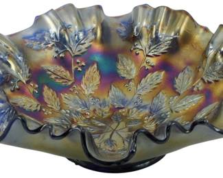 688 - Fenton Cobalt Blue Holly Berry Carnival Bowl (Description): Vintage Fenton cobalt blue carnival glass  bowl in the Holly and Berry pattern. This  decorative piece features a striking  iridescent finish with rich amber, purple,  and blue hues characteristic of fine carnival glass. The bowl showcases an intricately  molded holly leaf and berry design radiating  from the center, with a beautifully ruffled  edge adding dimensional appeal. Measures 3  inches tall by 8.5 inches in diameter.